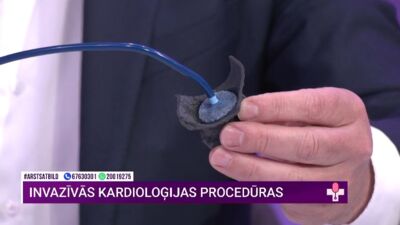 Kardiologs demonstrē ierīci, ar kuru noslēdz priekškambara austiņu